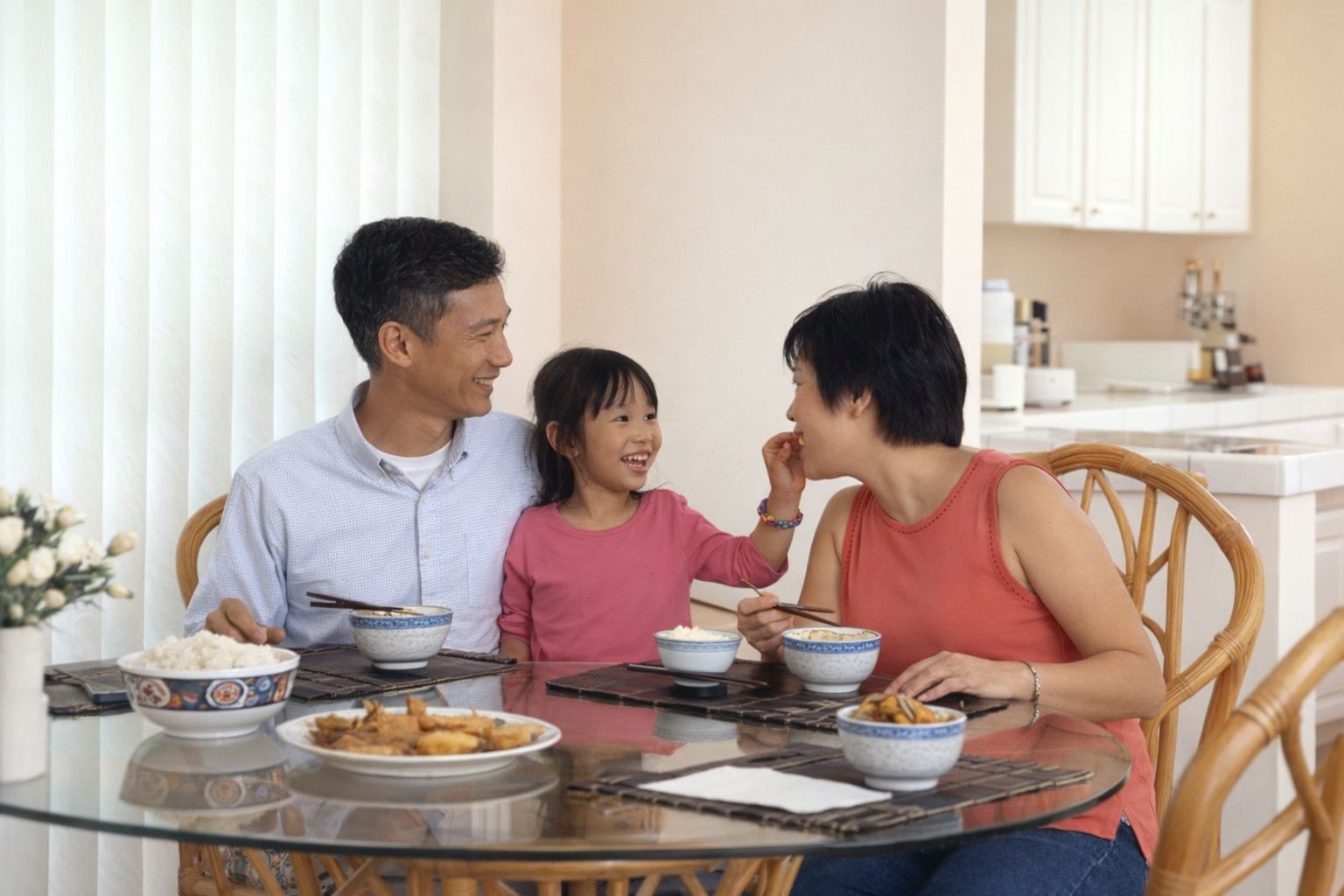 En familj njuter av en hälsosam middag tillsammans vid ett runt matbord.